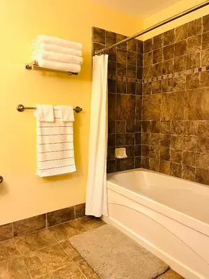 a bathroom with a tub and a shower with towels at The Appalachian at Mountain Creek in Vernon Township