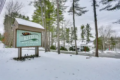 a sign in the snow in front of a building at All-Season Lake Wallenpaupack Condo with Views in Greentown