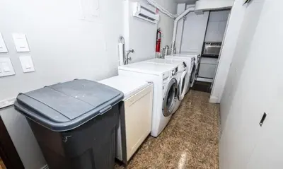 a laundry room with a sink and a washer and dryer at Synergy Madison in New York