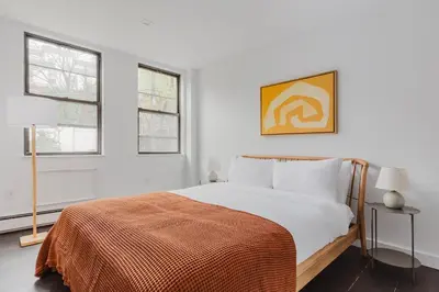 a white bedroom with a bed and two windows at Blueground Dumbo rooftop wd nr bridge NYC-1668 in Brooklyn