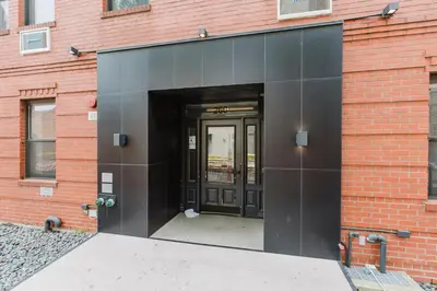 an entrance to a brick building with a black door at Blueground Dumbo rooftop wd nr bridge NYC-1668 in Brooklyn
