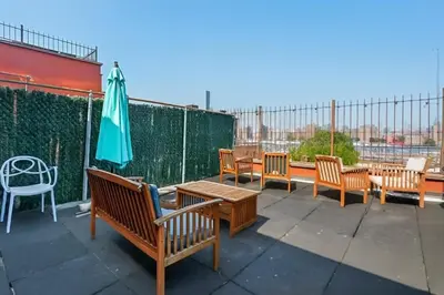 a group of benches and an umbrella on a patio at Blueground Dumbo rooftop wd nr bridge NYC-1668 in Brooklyn