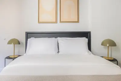 a bedroom with a white bed with two lamps at Blueground Murray Hill view nr Empire State NYC-1911 in New York
