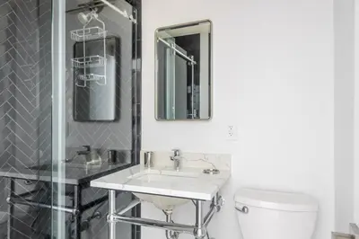 a bathroom with a sink and a toilet and a mirror at Blueground Murray Hill view nr Empire State NYC-1911 in New York