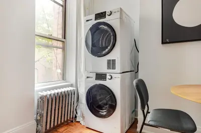 two washing machines stacked on top of each other in a room at Blueground Alphabet City washer nr Tompkins Square Park NYC-2161 in New York