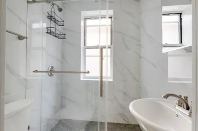 a white bathroom with a sink and a shower at Blueground Alphabet City washer nr Tompkins Square Park NYC-2161 in New York