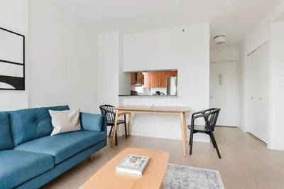 a living room with a blue couch and a table at Blueground Kips Bay rooftop nr NYC Skyline NYC-2158 in New York