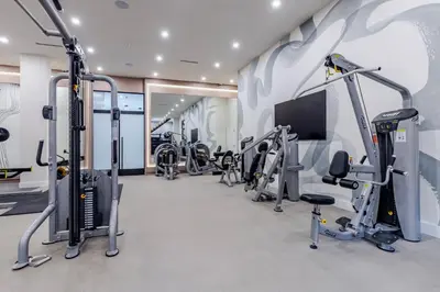 a gym with a row of treadmills and machines at Blueground Downtown Brooklyn rooftop nr Brooklyn Bridge NYC-2186 in Brooklyn