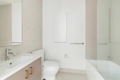 a white bathroom with a toilet and a sink at Blueground Downtown Brooklyn rooftop nr Brooklyn Bridge NYC-2186 in Brooklyn