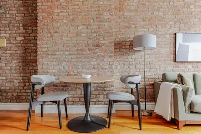 a table and chairs in front of a brick wall at Blueground Nolita view nr Washington Square NYC-2051 in New York