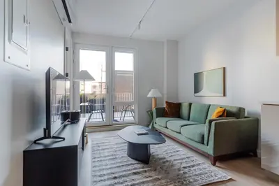a living room with a couch and a table at Blueground Greenpoint rooftop nr Transmitter Park NYC-2196 in Brooklyn
