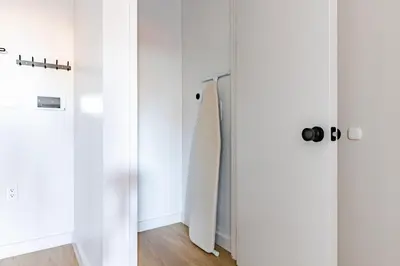 a room with white walls and a mirror at Blueground Greenpoint rooftop nr Transmitter Park NYC-2196 in Brooklyn