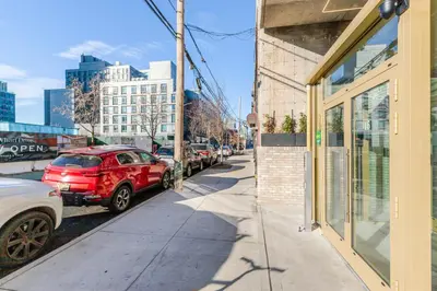 a red car parked on a sidewalk next to a building at Blueground Greenpoint rooftop nr Transmitter Park NYC-2196 in Brooklyn