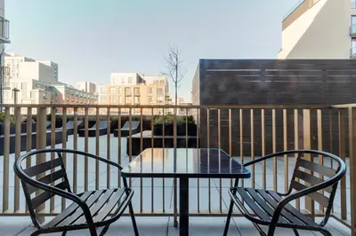a table and two chairs sitting on a balcony at Blueground Greenpoint rooftop nr Transmitter Park NYC-2196 in Brooklyn