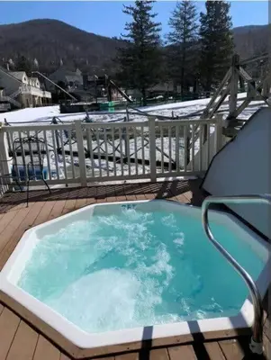 a hot tub on a deck with snow on it at Mountain Getaway Suite Ski OnOff Jiminy Peak - Fully Redone Decor in Hancock