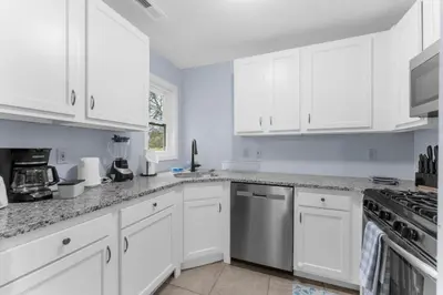 a white kitchen with white cabinets and appliances at Willow Haven 2BR Cozy Retreat, Close to Hartford in Manchester