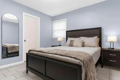 a bedroom with a large bed and a mirror at Willow Haven 2BR Cozy Retreat, Close to Hartford in Manchester
