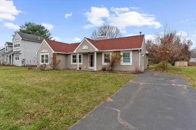 a white house with a red roof and a driveway at Willow Haven 2BR Cozy Retreat, Close to Hartford in Manchester