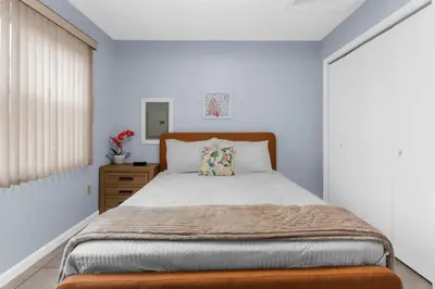a bedroom with a large bed with a wooden headboard at Willow Haven 2BR Cozy Retreat, Close to Hartford in Manchester