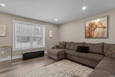 a living room with a couch and a horse painting on the wall at Evergreen Villa Poconos - Hot Tub, Fire Pit, Close to Kalahari, Great Wolf Lodge and Camelback in Tobyhanna