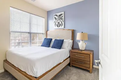 a bedroom with a bed with blue walls and a window at Landing Stunning 2BD Gym in New Haven