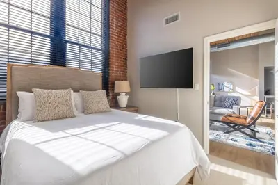 a bedroom with a bed and a flat screen tv at Landing Stylish 1BD Gym Courtyard in New Haven
