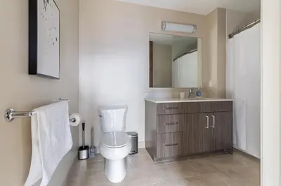 a bathroom with a toilet and a sink and a mirror at Landing Stylish 1BD Gym Courtyard in New Haven
