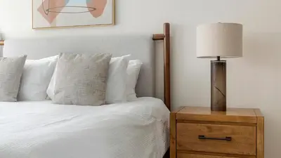 a bedroom with a bed with a lamp on a nightstand at Landing Spectacular 2BD Yoga Studio Game Room in Vernon