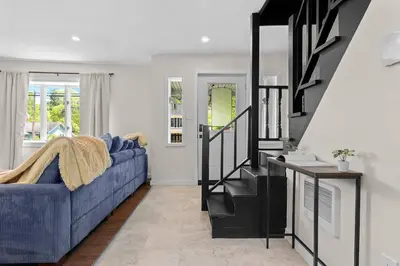 a living room with a blue couch and a staircase at Skiing Close By! Firepit & Game Room in Ashland