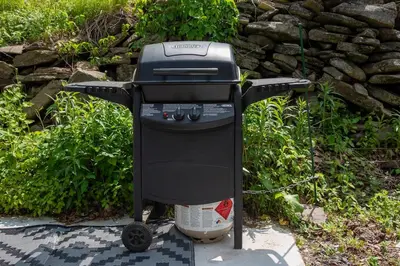 a barbecue grill sitting on the ground next to a stone wall at Skiing Close By! Firepit & Game Room in Ashland