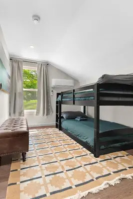 a bedroom with two bunk beds and a rug at Skiing Close By! Firepit & Game Room in Ashland