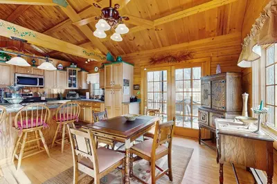 a kitchen with a wooden ceiling and a table and chairs at Chimney Hill Retreat in Wilmington