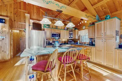 a kitchen with wooden cabinets and a island with bar stools at Chimney Hill Retreat in Wilmington