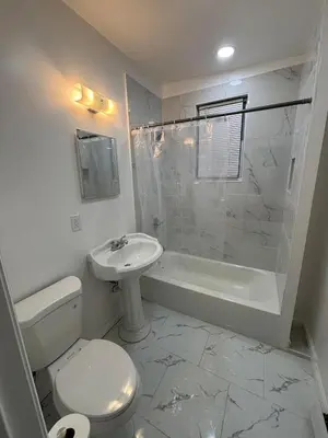 a white bathroom with a toilet and a sink at The loft 2 bedroom apartment in Newark