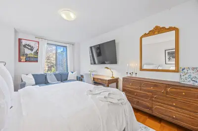 a bedroom with a bed and a mirror and a dresser at Chelsea 1BR in Shared Apt with Laundry and Rooftop in New York