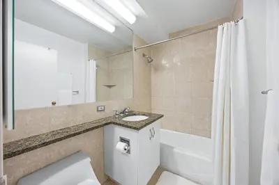 a bathroom with a toilet and a sink and a tub at Chelsea 1BR in Shared Apt with Laundry and Rooftop in New York