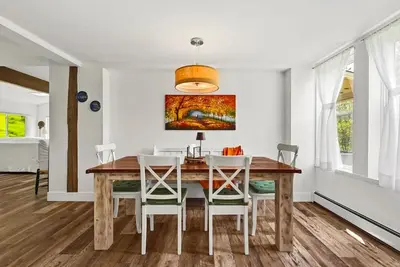 a dining room with a wooden table and white chairs at Country Chic 3BR Retreat Near All Star Village in Treadwell