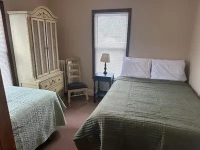a bedroom with a bed and a dresser and a window at Charming Four Bedroom House in Tannersville