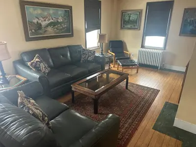 a living room with a leather couch and a coffee table at Charming Four Bedroom House in Tannersville