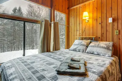 a bed in a room with a large window at Ski, Hike and More! Year-Round Retreat in West Dover in West Dover