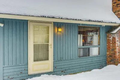 a blue house with a yellow door in the snow at Ski, Hike and More! Year-Round Retreat in West Dover in West Dover