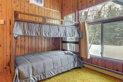 a bedroom with a bed in a wooden wall at Ski, Hike and More! Year-Round Retreat in West Dover in West Dover