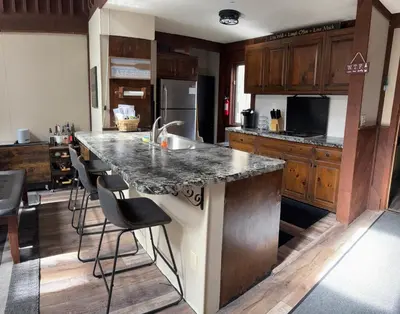 a kitchen with a large island with a sink and stools at Ambro's Place in Lake Ariel