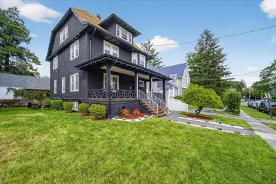 a black house with a large grassy yard at 14 Guest, 9 Bed, Family Getaway- 30 min from NYC in New Rochelle