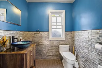 a blue bathroom with a sink and a toilet at 14 Guest, 9 Bed, Family Getaway- 30 min from NYC in New Rochelle
