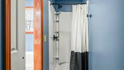 a shower in a bathroom with a shower curtain at Epic Poconos Pad - Pool - Hot Tub - Gym - Golf Sim in East Stroudsburg