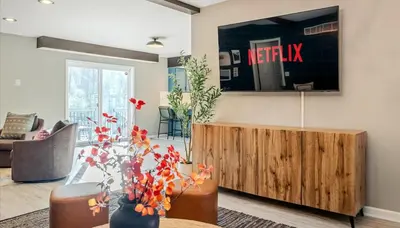 a living room with a tv on the wall at Epic Poconos Pad - Pool - Hot Tub - Gym - Golf Sim in East Stroudsburg