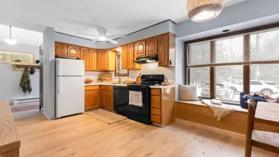 a kitchen with wooden cabinets and a white refrigerator at Catskills Mountain Home Near Windham w Fireplace Open Living Deer Run Lodge by AvantStay in Prattsville