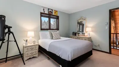 a bedroom with a bed with a camera on a tripod at Catskills Mountain Home Near Windham w Fireplace Open Living Deer Run Lodge by AvantStay in Prattsville