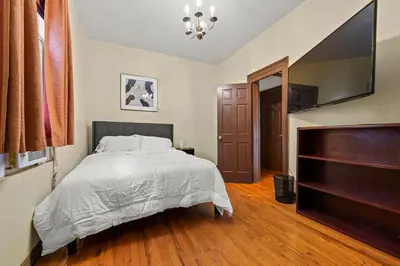a bedroom with a bed and a flat screen tv at Massive NYC House with Pool Table in Yonkers